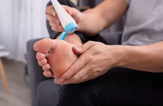 man applying foot repair cream to his foot